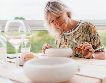 Dame kijkt vol blijdschap naar het bord in culinair restaurant