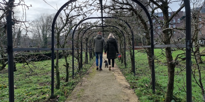 Twee wandelaars door het Perenlaantje in de Ursulinentuin, een van de Geheime Tuinen van Sittard