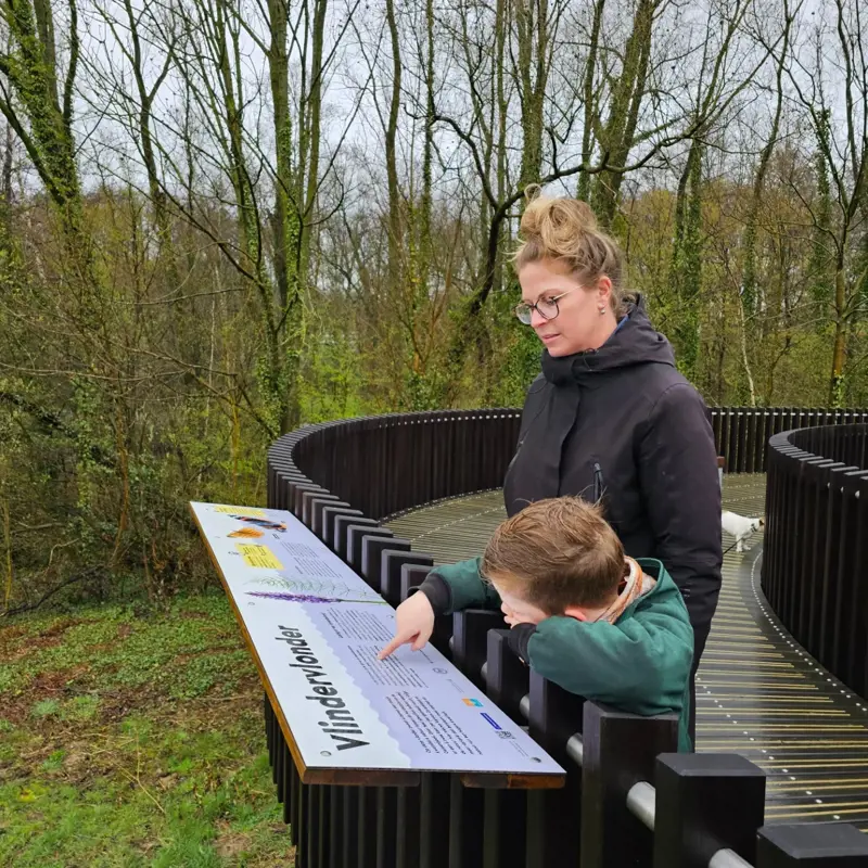 Een Moeder En Zoon Kijken Naar Het Informatiebord Van De Vlindervlonder