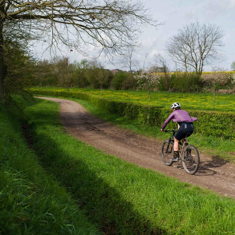 Een mountainbiker volgt het onverharde fietspad