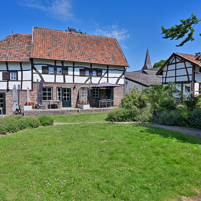 Uitzicht vanaf de tuin op vakwerk vakantiewoning De Witte Olifant in Noorbeek