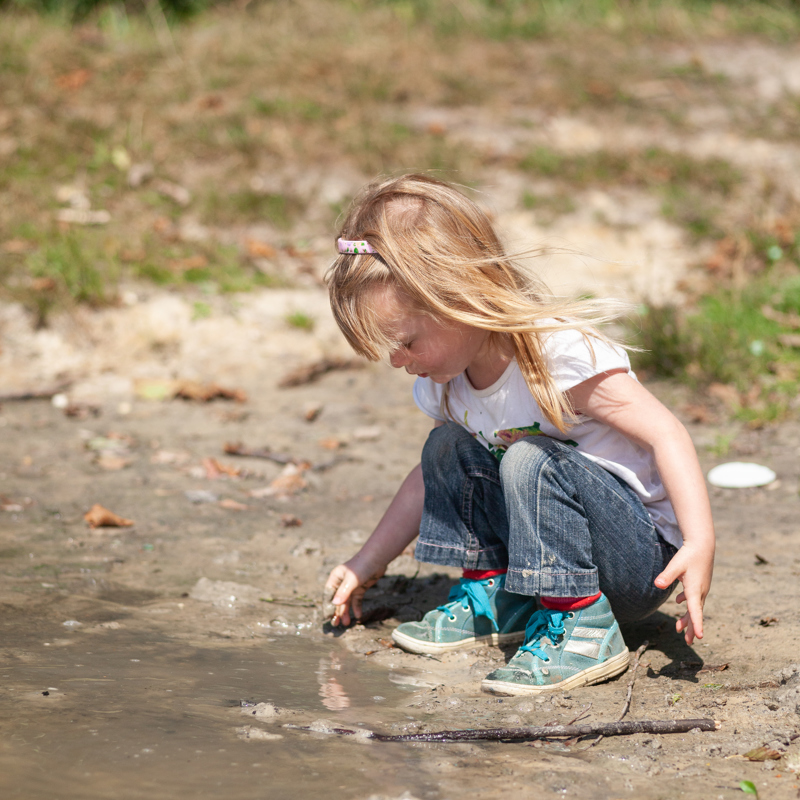 Meisje speelt in de modder bij de Schinveldse Bossen