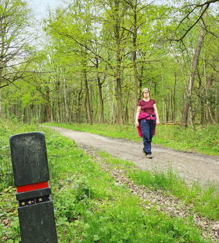 Boswachter Ellen wandelt over een wandelpad in de Schinveldse Bossen