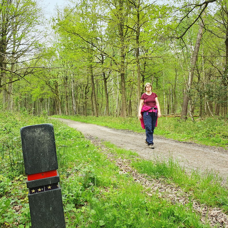 Boswachter Ellen wandelt over een wandelpad in de Schinveldse Bossen