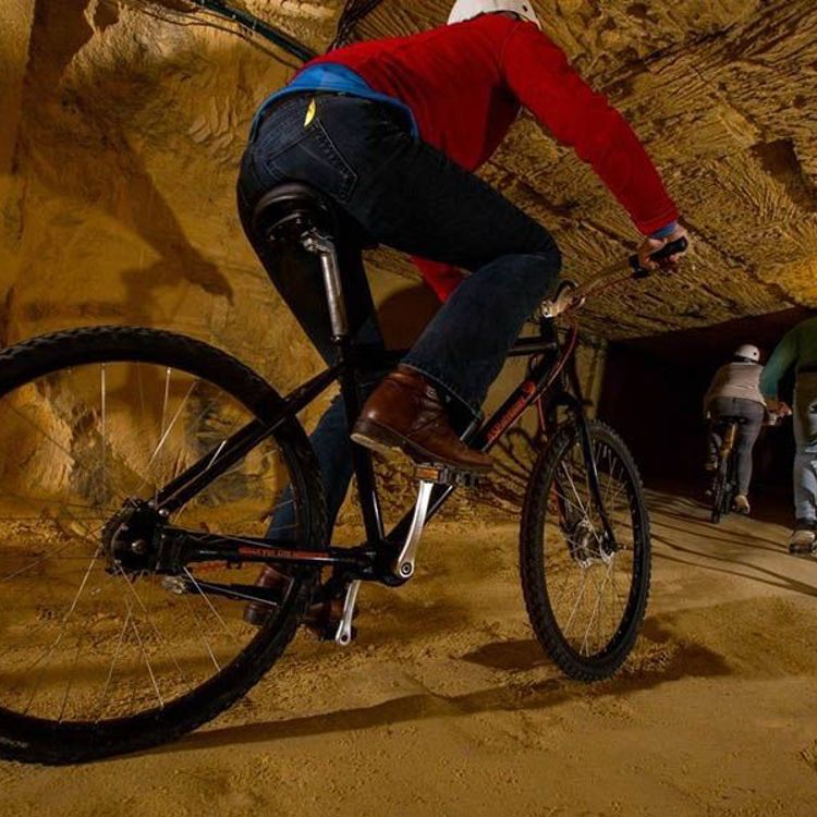 3 mensen op mountainbikes in de grotten van Valkenburg