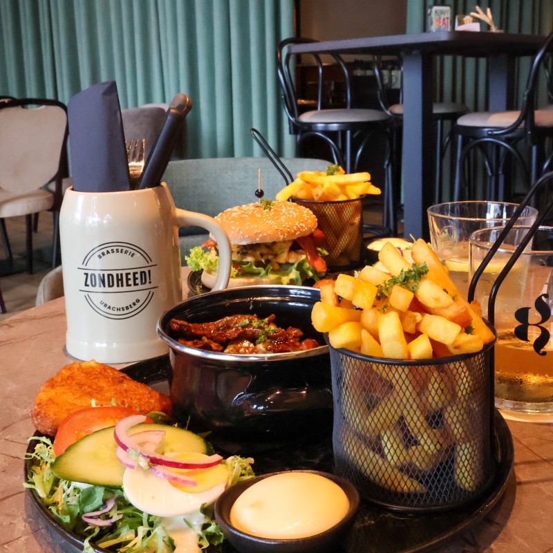 Twee hoofdgerechten op tafel bij een gezellige brasserie. 