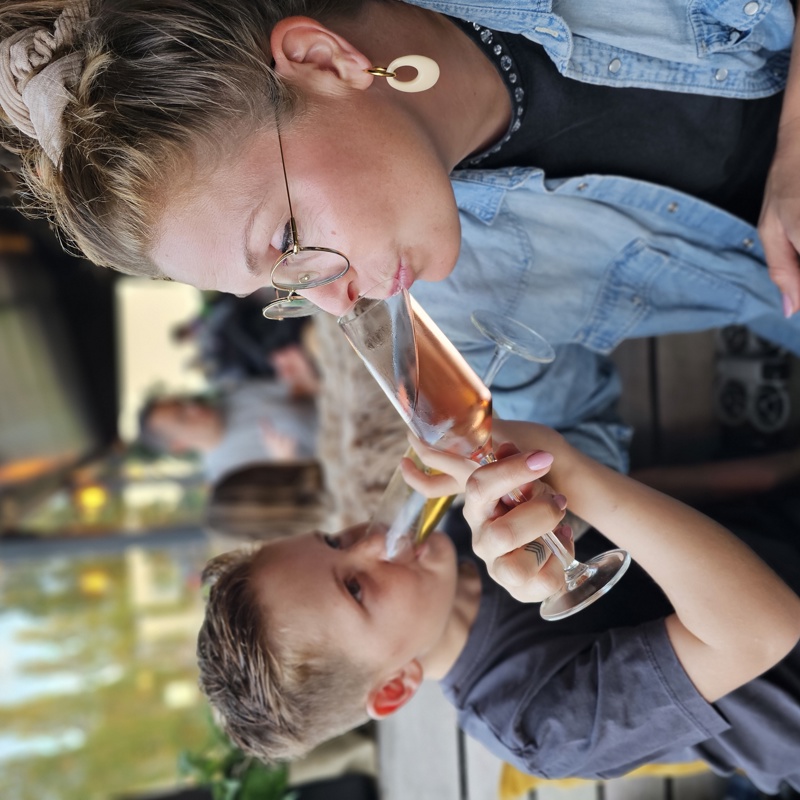 Moeder en zoon wikkelen hun armen om elkaar heen en drinken van hun drankje