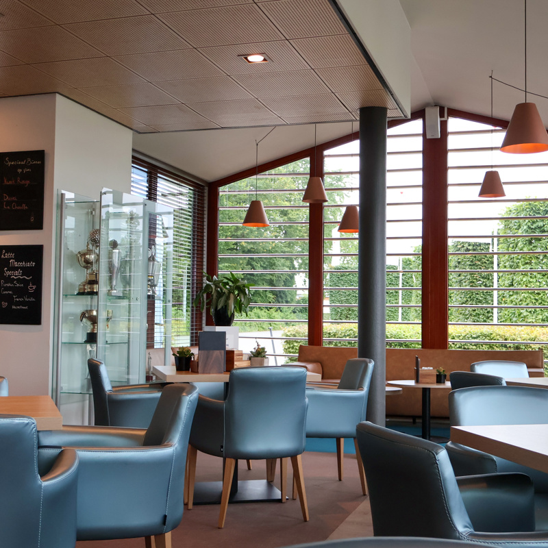 Interieur van een restaurant met zwarte lederen stoelen.