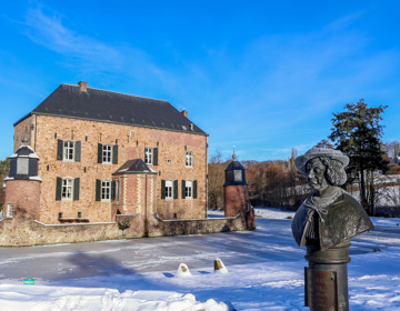 Kasteel omringd door een bevroren meer en sneeuw