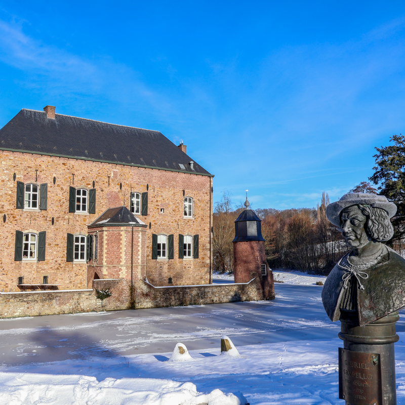 Kasteel omringd door een bevroren meer en sneeuw