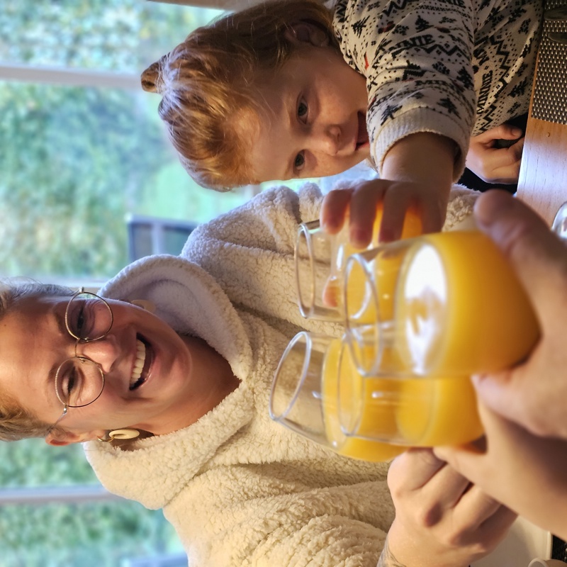 Een familie proost met jus d'orange in hun vakantiehuisje