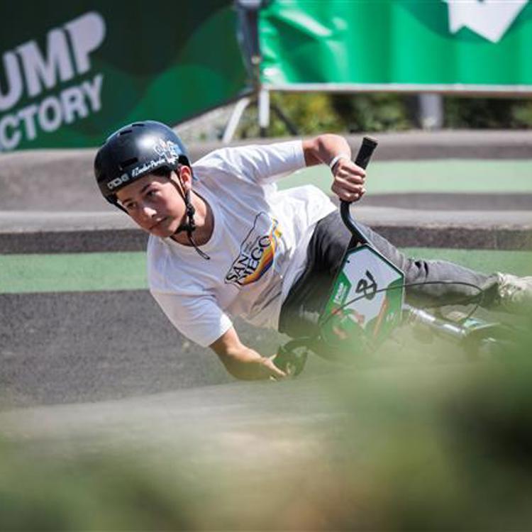 Jongen op BMX gaat bijna horizontaal door de bocht