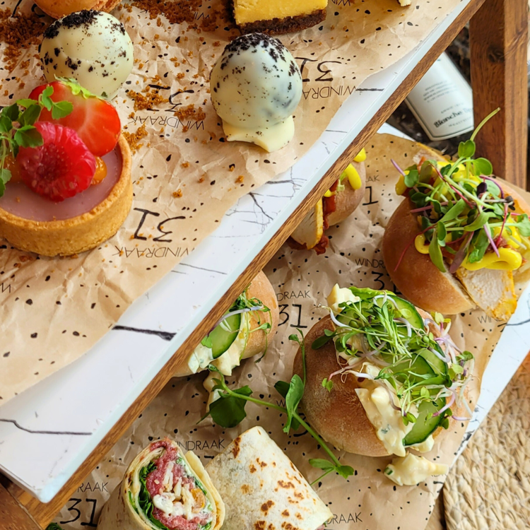 Etagère met diverse hartige en zoete hapjes tijdens high tea in zuid limburg.