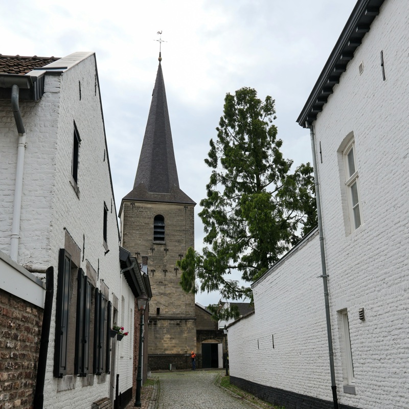 Steegje met klinkers met doorkijkje naar de kerk van Eijsden.