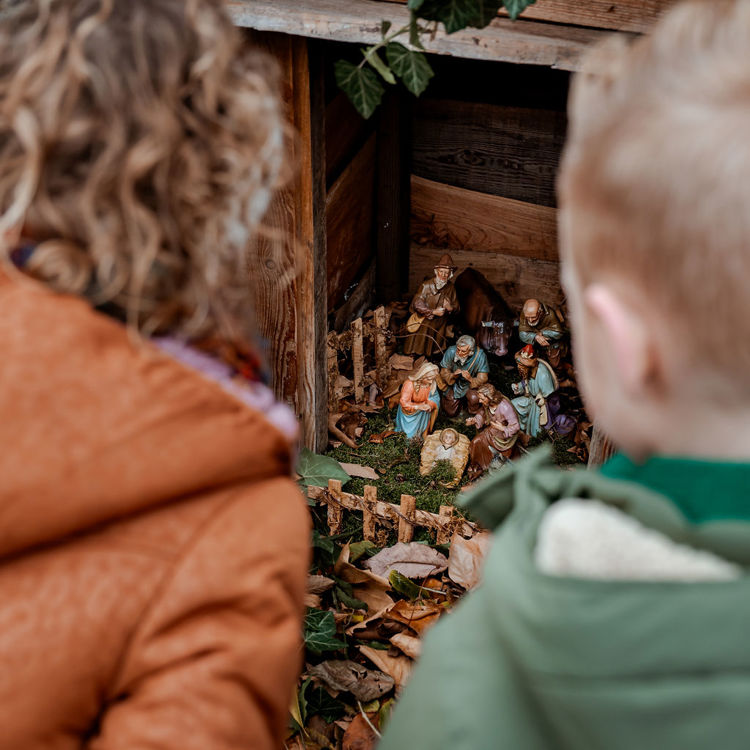 Doorkijkje met 2 kinderen die naar kerststal kijken