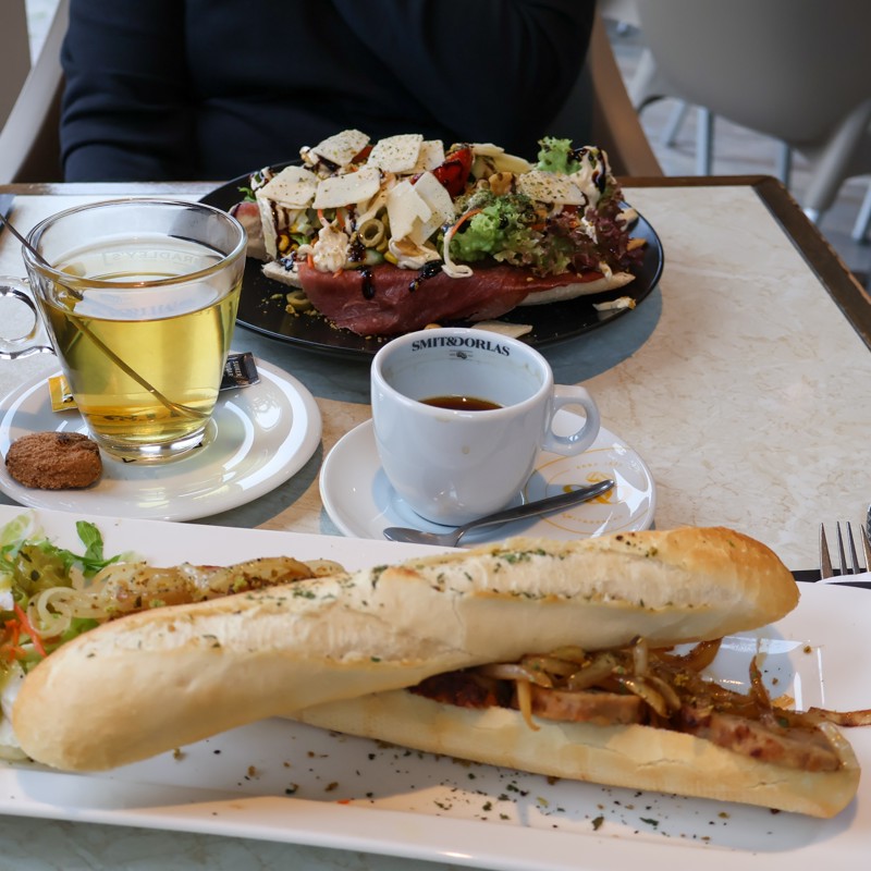 Twee lunchgerechten op tafel met koffie en thee erbij. 