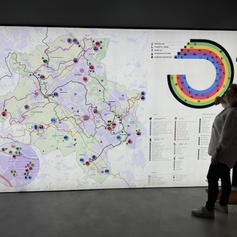 Medewerker met een grote plattegrond in de Visit Zuid-Limburg Experience in Heerlen