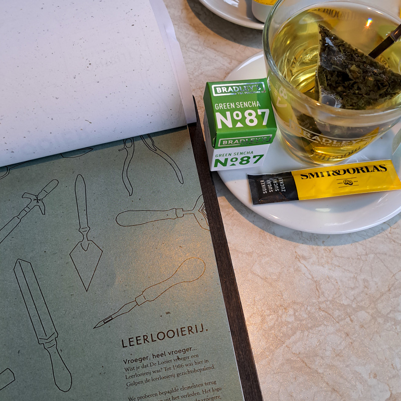 menukaart op tafel bij de looier met een kop thee erbij. 