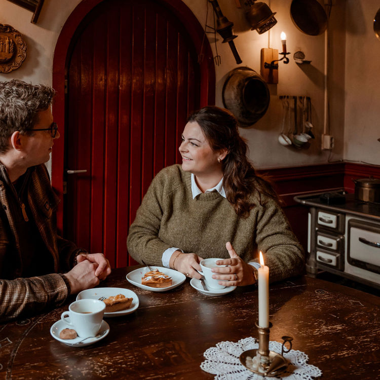 Koppel geniet in gezellig bruin café van een kop koffie met stuk limburgse vlaai.