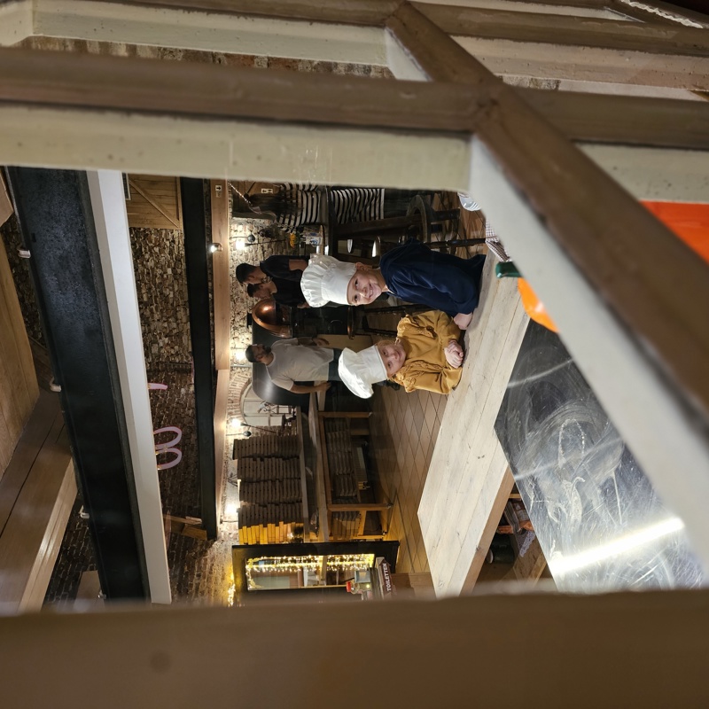 Twee kids met een koksmuts nemen een kijkje bij Hoeve Cobelli in de keuken