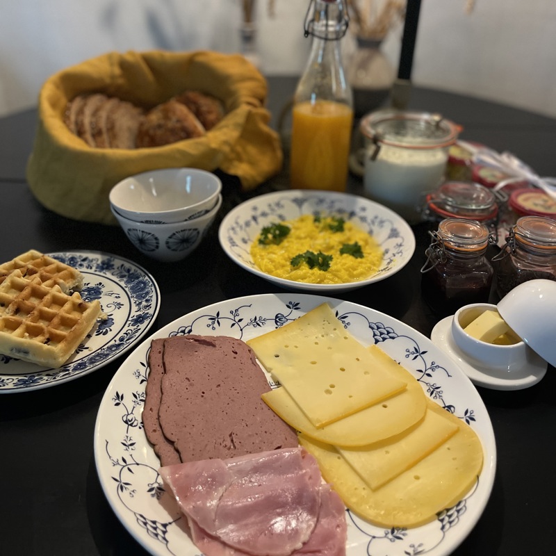 Tafel met wafels, vleeswaren en brood voor het ontbijt