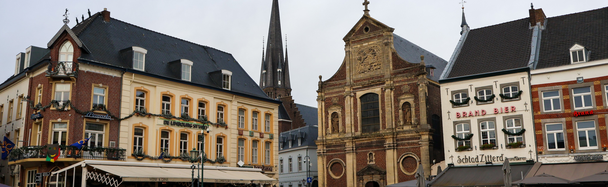 Markt in sittard met oude basiliek en restaurants. 